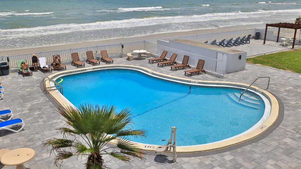 an overhead view of a swimming pool next to the beach at Driftwood Beach Motel in Ormond Beach