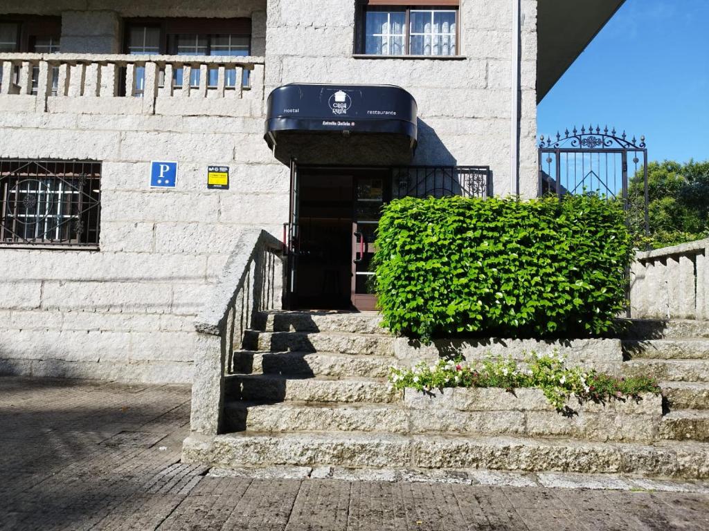 a building with stairs leading up to a door at Casa Ruliña in Lalín