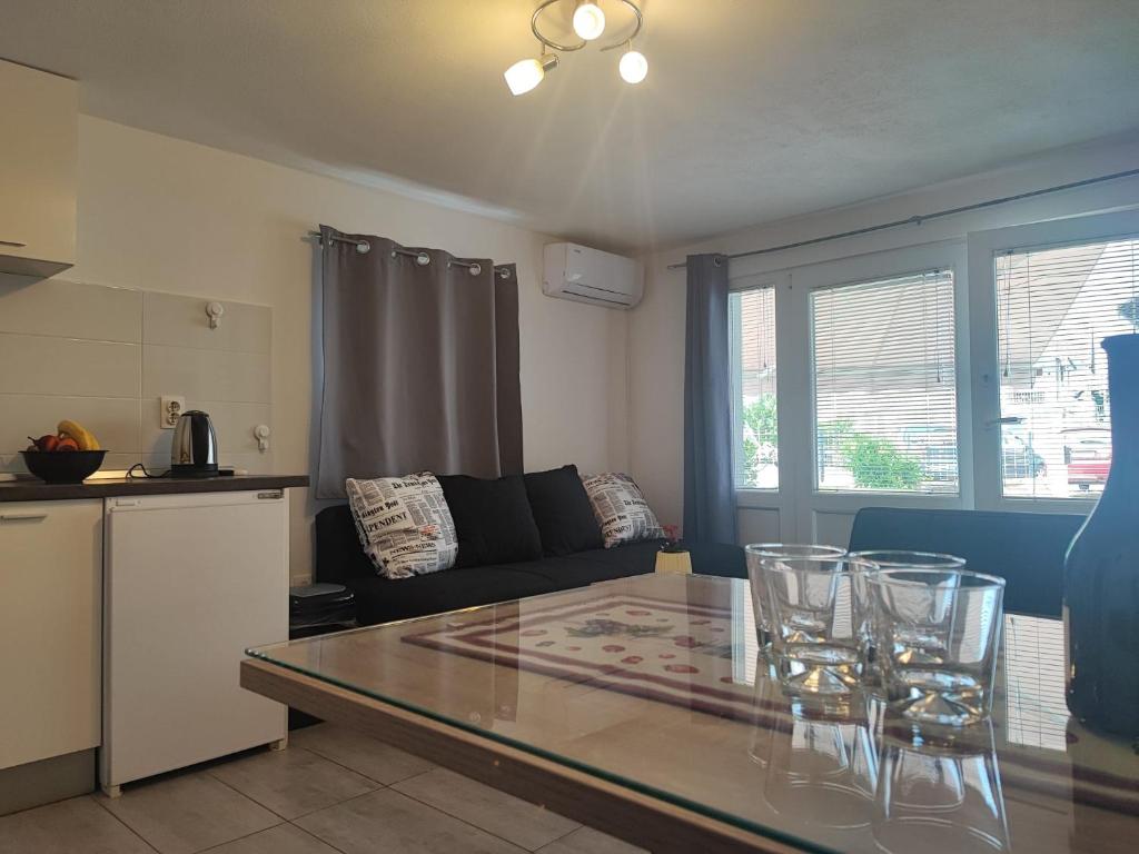 a kitchen and a living room with a glass table at Apartman Luka in Vodice
