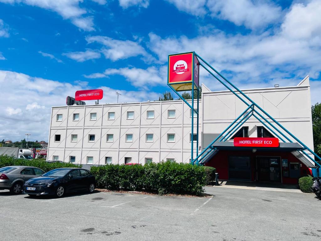 a large white building with a sign on the front of it at Hotel First Eco Savigny Villemoisson Centre Commercial Carrefour in Savigny-sur-Orge