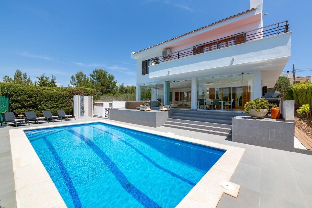 une villa avec une piscine en face d'une maison dans l'établissement Ferienhaus Casa Kristel, à Badia Gran