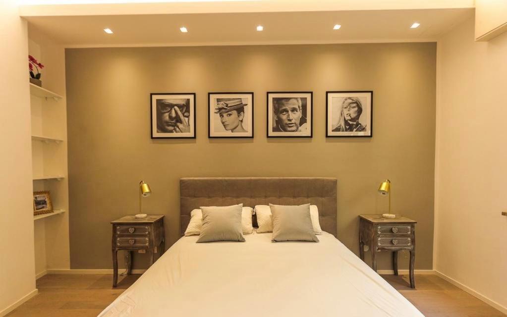 ein Schlafzimmer mit einem großen Bett mit vier Bildern an der Wand in der Unterkunft Casanova Luxury Home in Verona