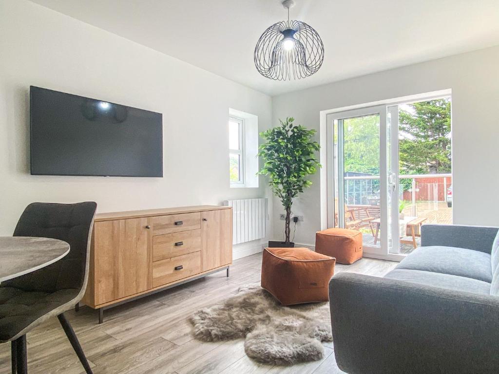 a living room with a couch and a tv on a wall at 2 Bedroom City Centre Apartment in High Wycombe with Parking in High Wycombe