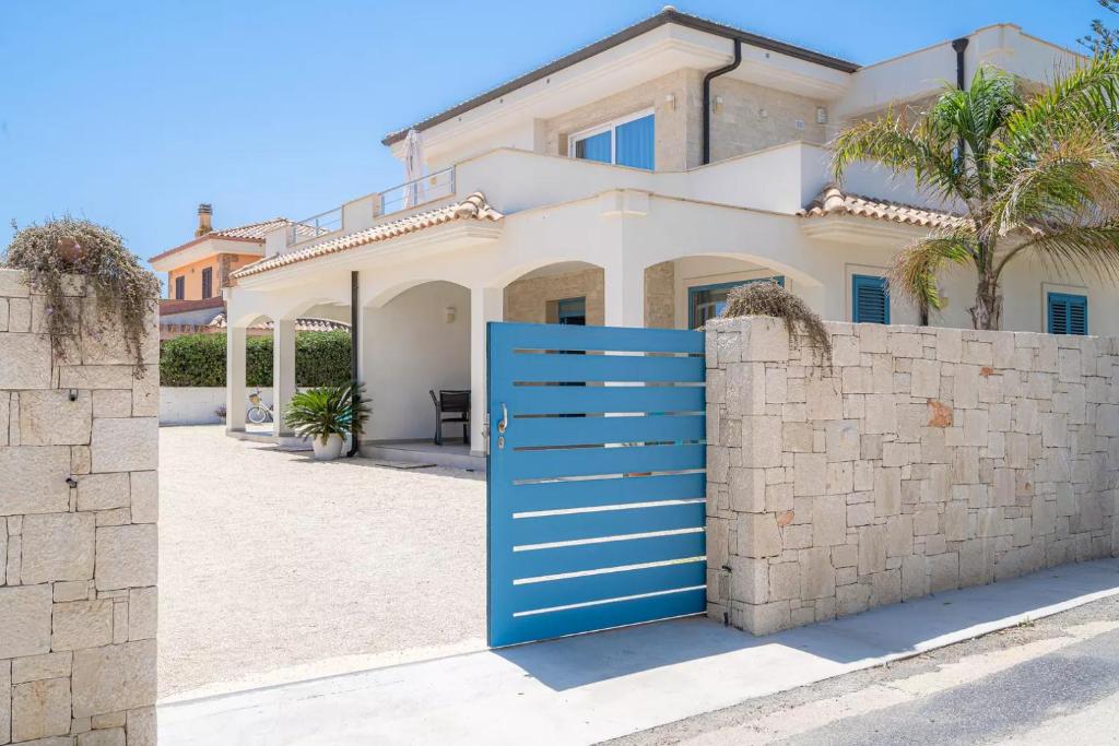 una casa con una puerta azul frente a una valla de piedra en Appartamenti San Lorenzo 1, en Reitani