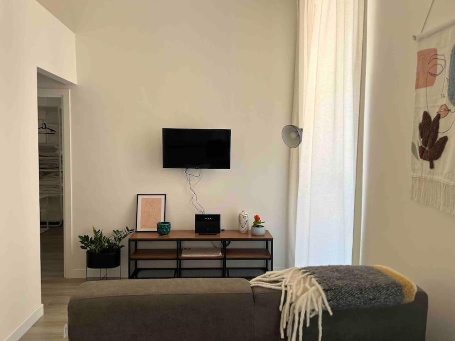 a living room with a couch and a tv on the wall at Colosseo Living Suites in Rome