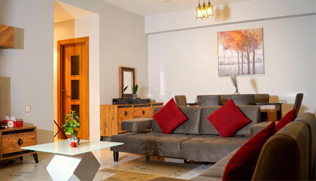AECO lovely 2 bedroom apartment for family and friends في مسقط: غرفة معيشة مع أريكة وطاولة