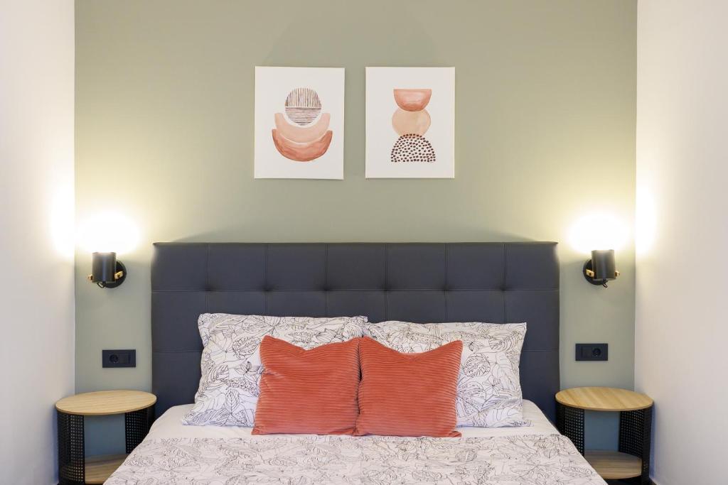 a bedroom with a bed with orange pillows and two tables at Apartments & Rooms Darrer in Poreč