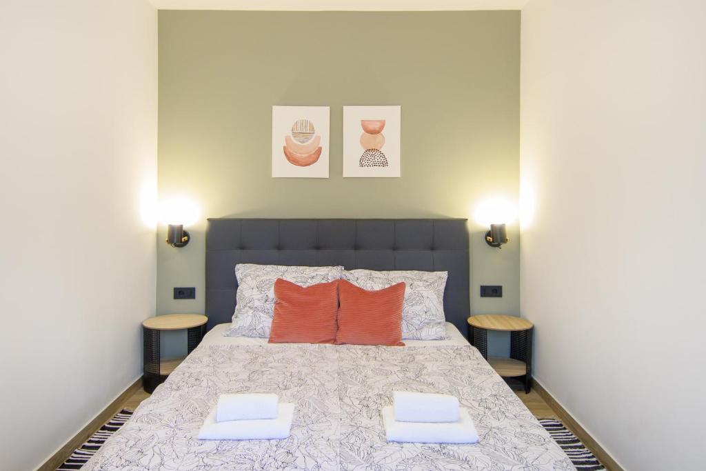 a bedroom with a bed with two orange pillows at Apartments & Rooms Darrer in Poreč