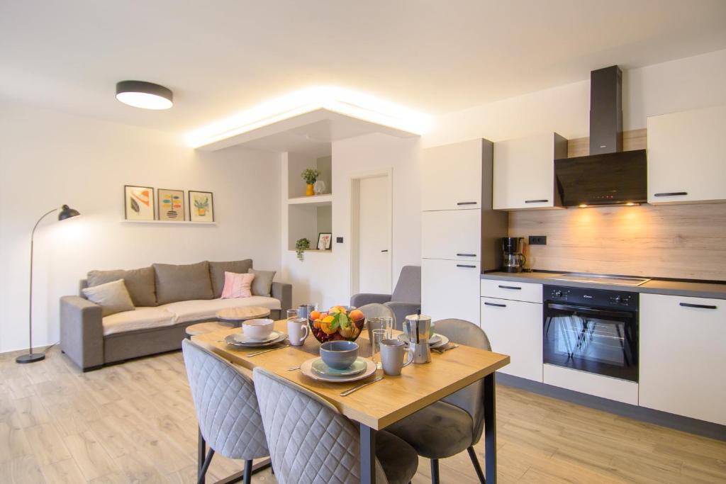 a kitchen and living room with a table and chairs at Apartments & Rooms Darrer in Poreč