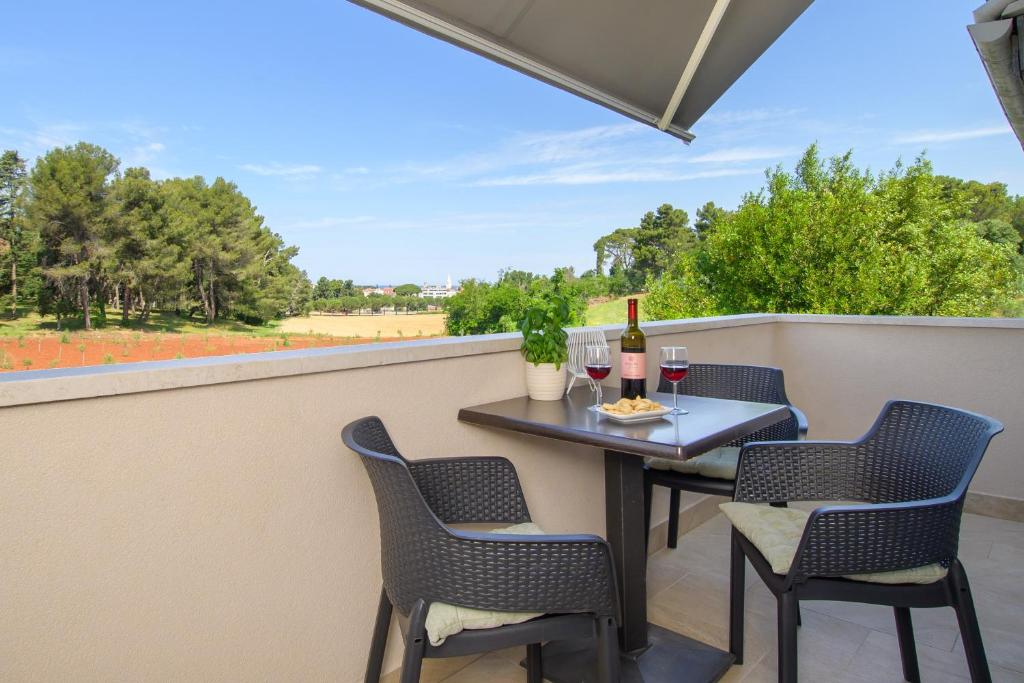 a patio with a table and chairs and wine bottles at Apartments & Rooms Darrer in Poreč