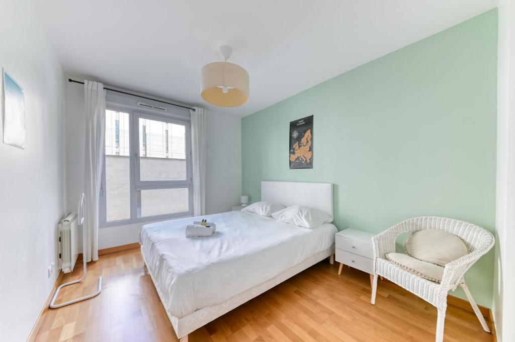 um quarto com uma cama, uma cadeira e uma janela em Appartement Résidence Quartier Vilette Paul Bert BOX GARAGE em Lyon