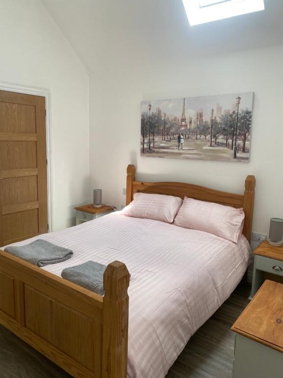 a bedroom with a wooden bed with a picture on the wall at Barn conversion in Perranwell