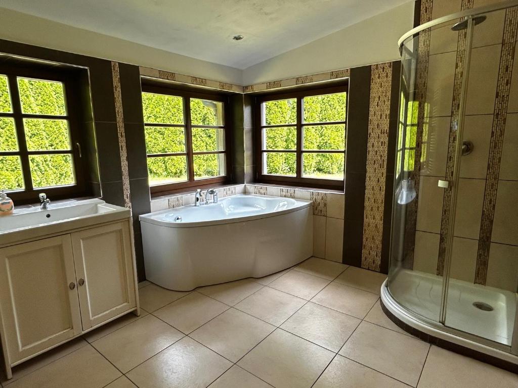 a large bathroom with a tub and a shower at log cabin in Czech-Saxon Switzerland in Šluknov