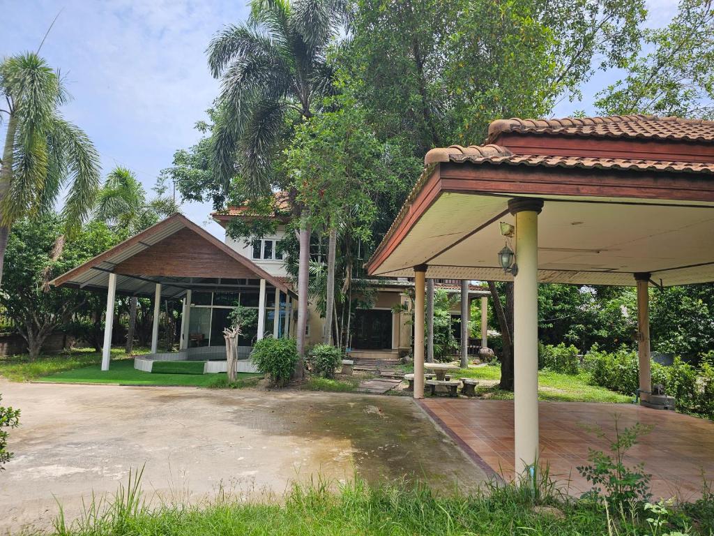 a house with a pavilion in front of it at Pool Villa Armthong Home in Ban Nong Toei