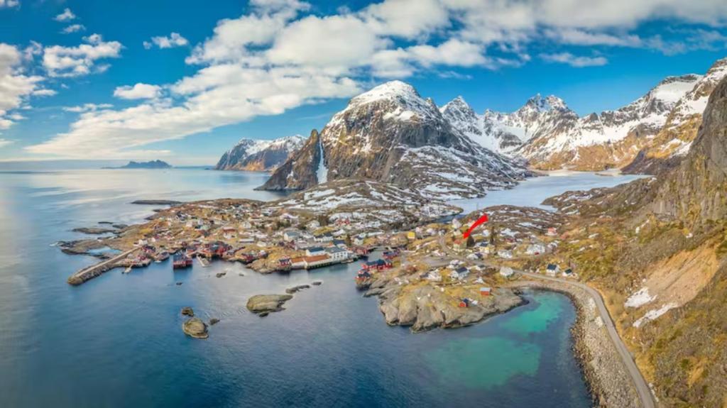 an aerial view of an island in the water with mountains at Å, the far end of Lofoten, top apartment. in Sørvågen