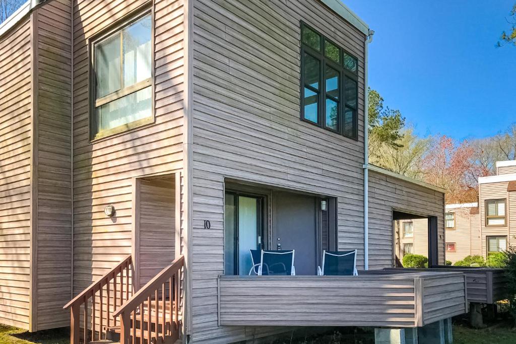 una casa con 2 sillas azules en el porche delantero en Borderlinks 10, en Ocean Pines