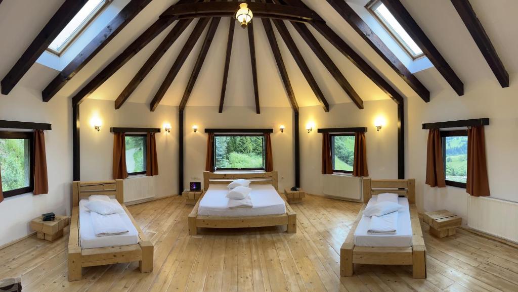 a room with two beds in it with windows at Pensiunea Poiana Izvoarelor in Vatra Dornei