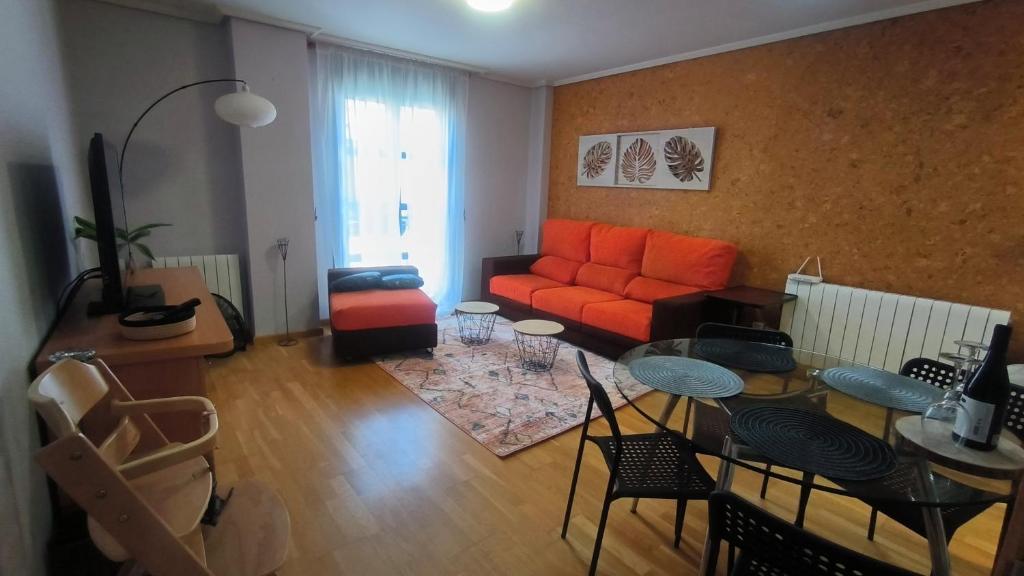 - un salon avec un canapé orange et une table dans l'établissement El Arca, à Ponferrada