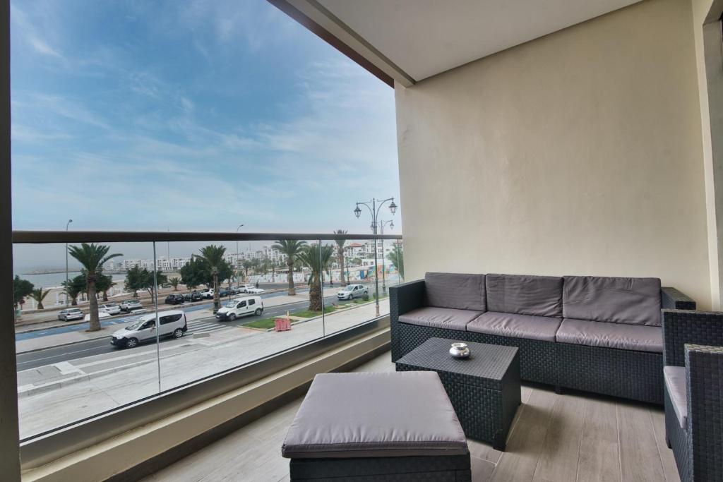 a living room with a couch and a large window at New Sea Front Apartment 135mq with Unlimited Wi-Fi in Agadir