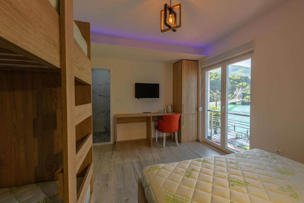 1 dormitorio con cama, escritorio y ventana en Lakeside Luxury Apartments, en Jablanica