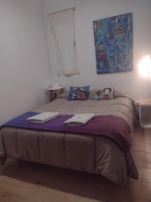 a bedroom with a bed with two towels on it at El Trotamundos in Puerto Pirámides