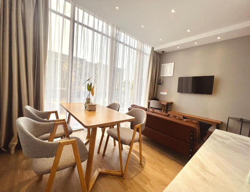 バタム・センターにあるoxy suites 1-01 at Shop House Meisterstadt Pollux Habibieのテーブル、椅子、ベッドが備わる客室です。