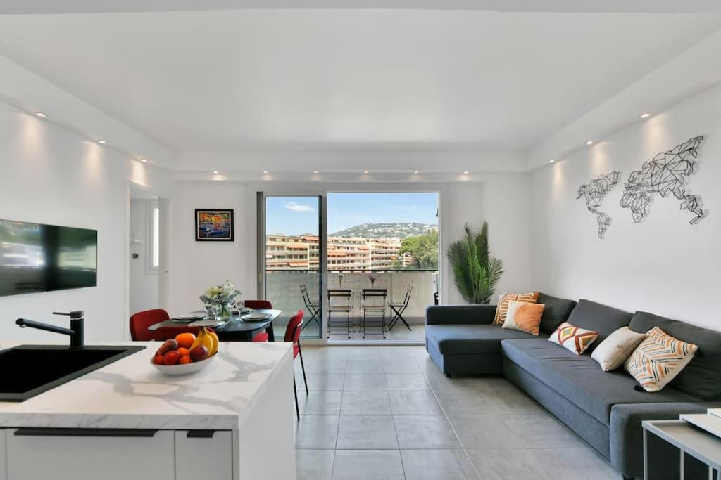 un salon avec un canapé bleu et une table dans l'établissement CROISETTE BEACH - Modern 2 Bdrs Best Location!, à Cannes