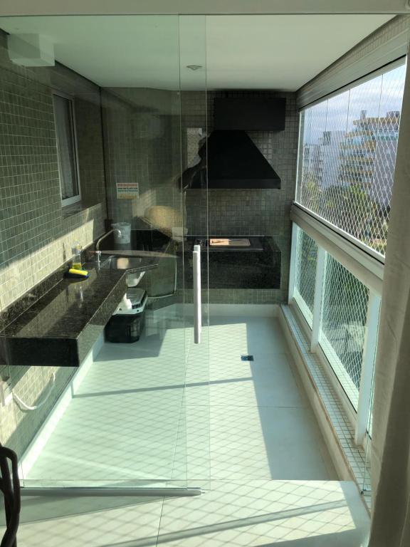 a glass room with a sink and a bathroom at Ilha da Madeira Resort - Cobertura com Jacuzzi in Riviera de São Lourenço