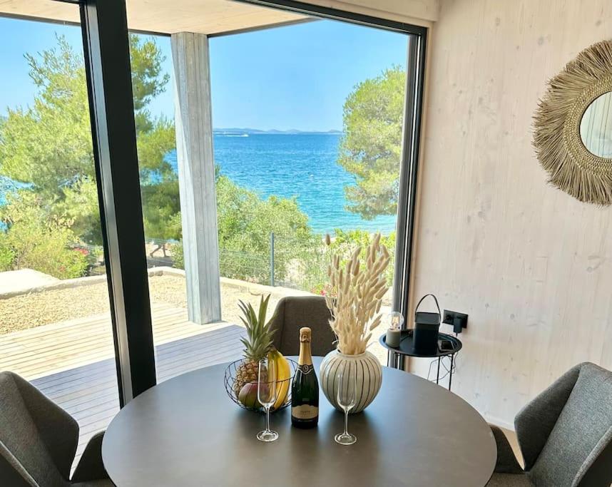 ein Esszimmer mit Tisch und Blick auf das Meer in der Unterkunft BEACHHOUSE #1 - Buqez Resort in Drage