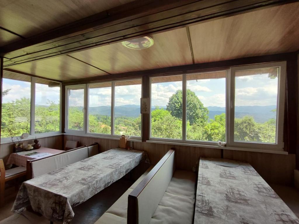 a room with two tables and windows with a view at Къща за гости Слънце Борики in Gabrovo