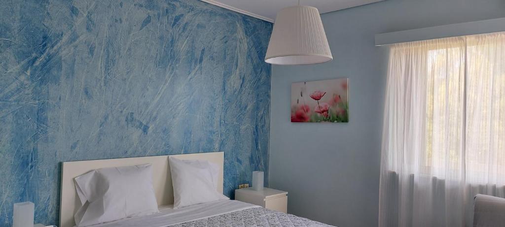 a blue bedroom with a bed and a blue wall at OIKIKA B10 in Artemida
