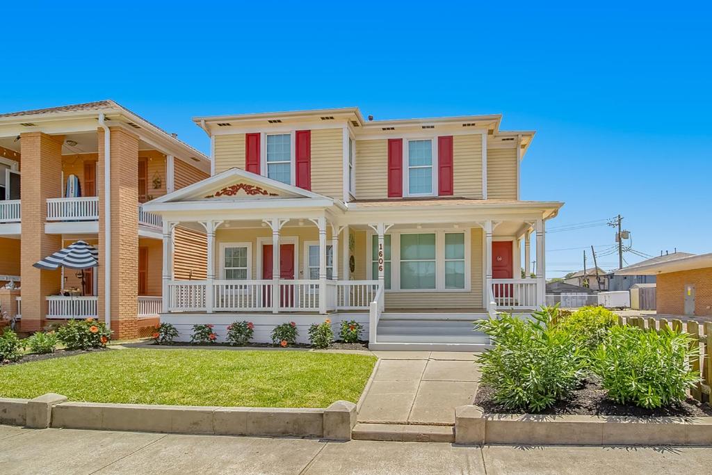 une grande maison avec volets rouges dans une rue dans l'établissement Coastal Breeze, à Galveston