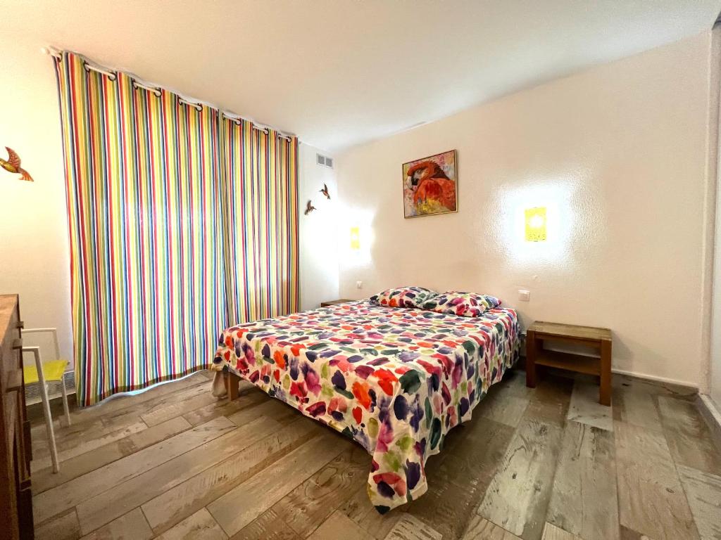 a bedroom with a bed and a large window at Couleur Caraïbes in Saint-François