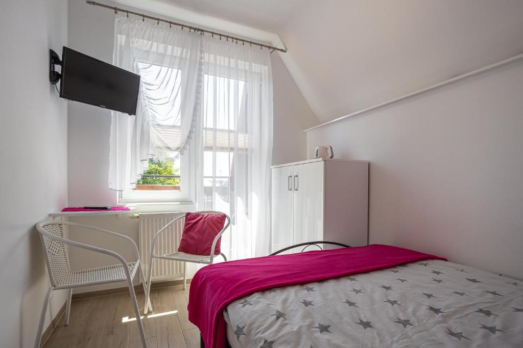 Schlafzimmer mit einem Bett, einem Schreibtisch und einem Fenster in der Unterkunft Pokoje u Kasi in Mielno