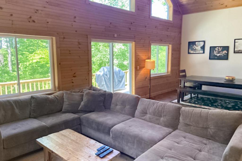 a living room with a couch and a piano at Shallow Brook in Jay