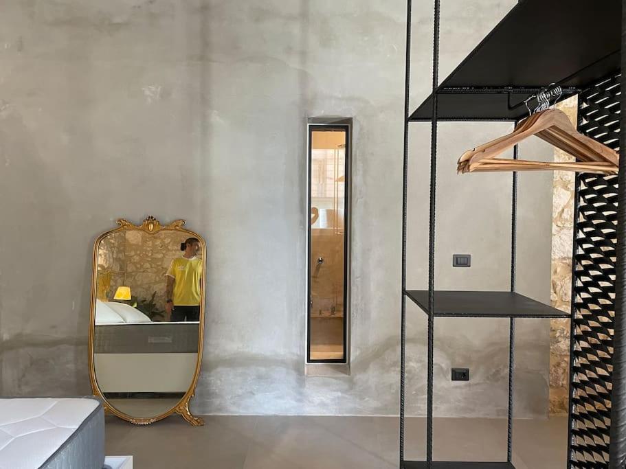 a man standing in front of a mirror in a room at Orty suite in Siracusa