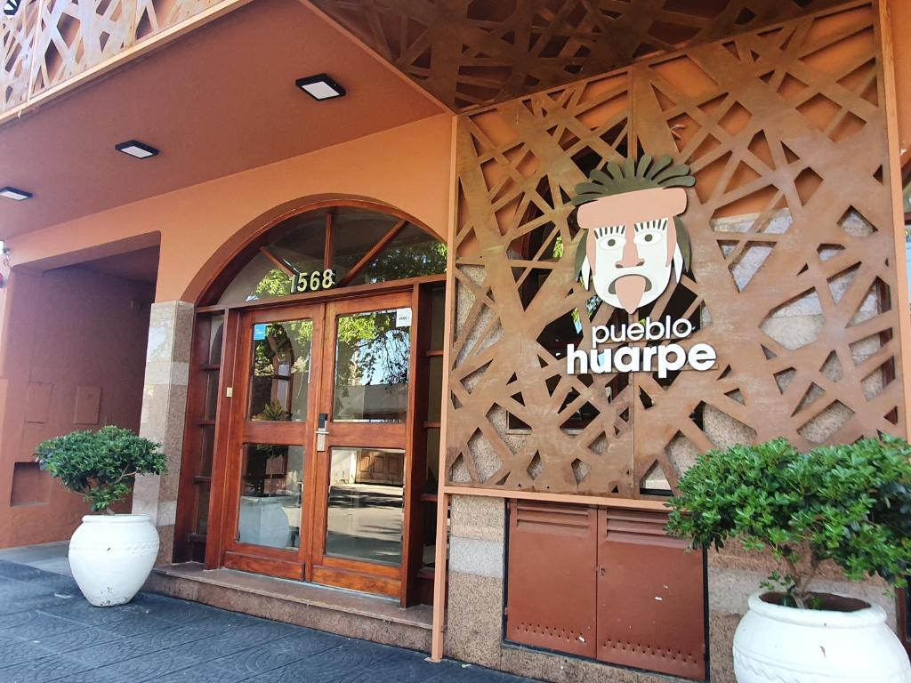 a restaurant with a sign on the side of a building at Hotel Pueblo Huarpe in San Luis