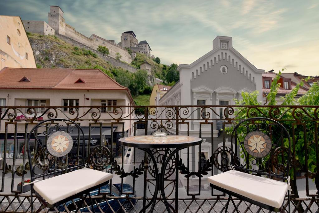 a balcony with a table and chairs and a castle at Apartmán s balkónom in Trenčín