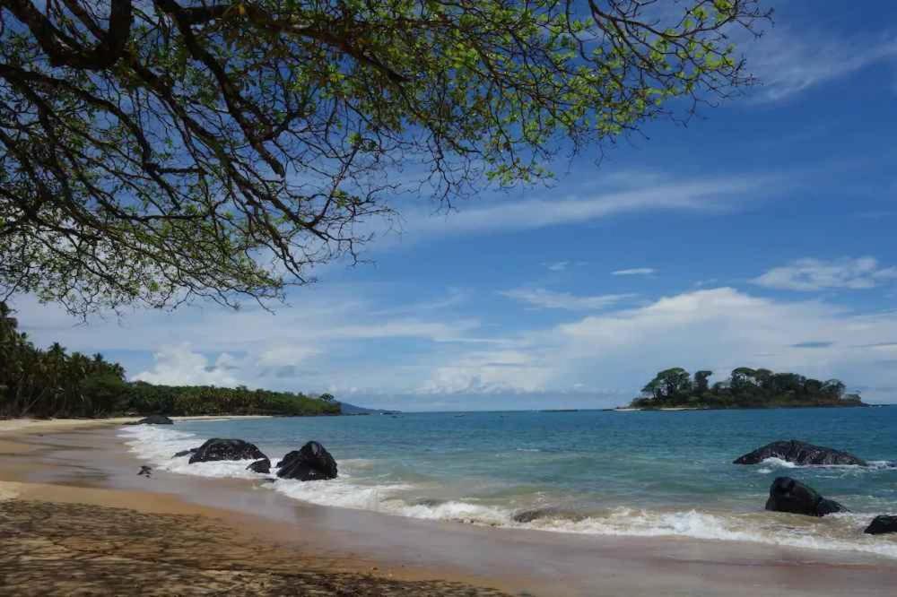 a view of a beach with rocks in the water at Robinson's Hut in Bure Town