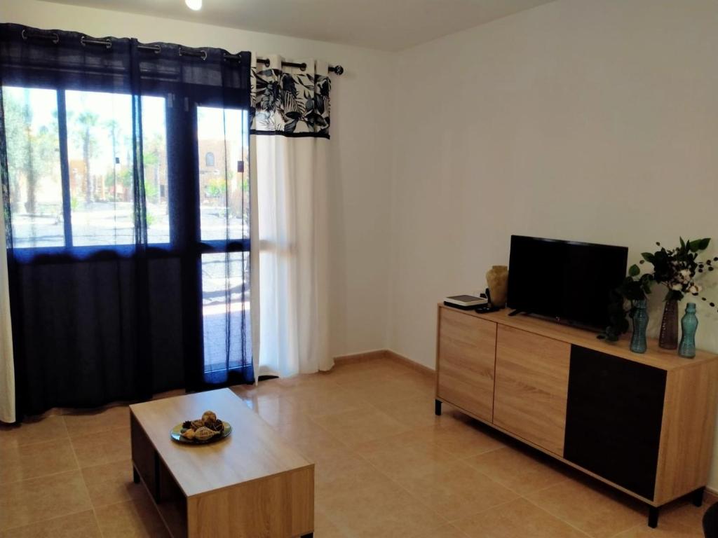 uma sala de estar com uma televisão de ecrã plano numa cómoda em Apto Puipana em Corralejo