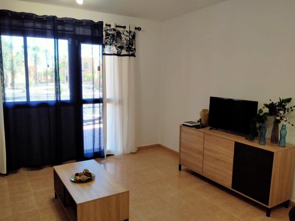 a living room with a flat screen tv on a dresser at Apto Puipana in Corralejo