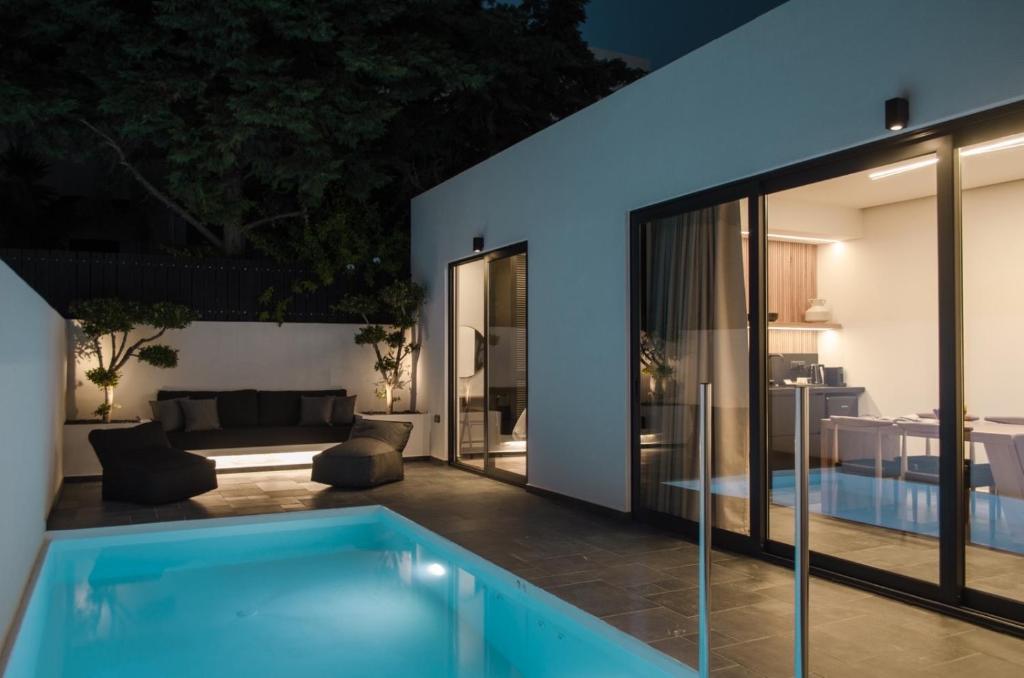 a villa with a swimming pool at night at Hygge Suites in Hersonissos