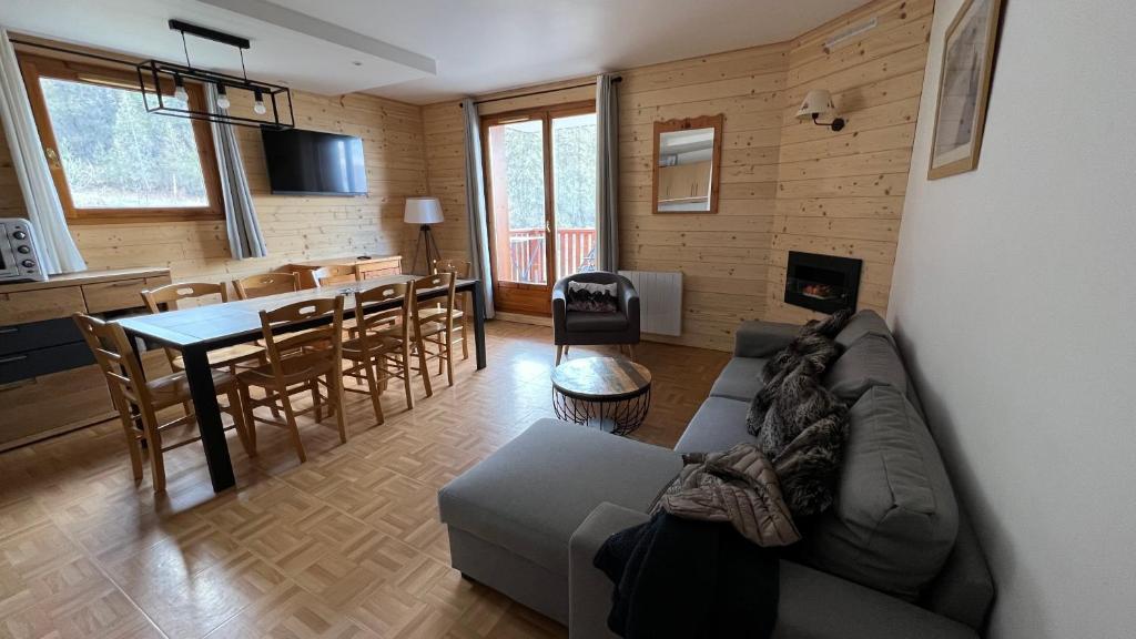 un salon et une cuisine avec un canapé et une table dans l'établissement Les Gentianes 1800, à Puy-Saint-Vincent