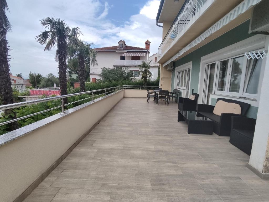 a balcony with chairs and tables on a building at Romantic New Superior Apartment Palma about 150m to Sandy beach in Crikvenica