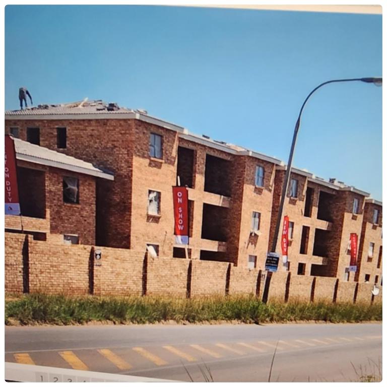 a brick building with signs on the side of it at Two Bedroom townhouse THE PINES ALBERTSDAL in Alberton