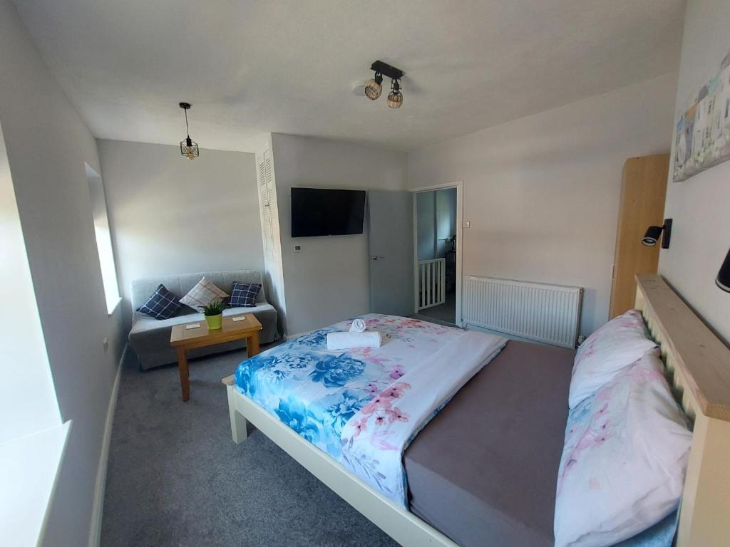 a small bedroom with a bed and a couch at Southwell Stays in Southwell