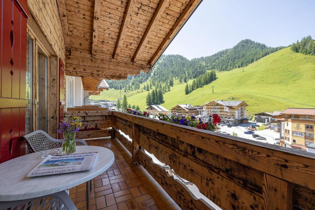 a balcony with a table and a view of a mountain at Hotel Sportalmmm, Hoch-Genuss in Zauchensee