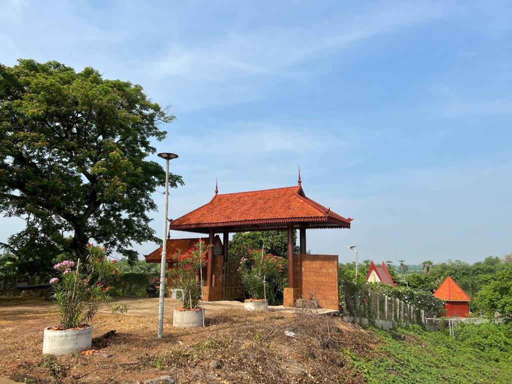 Toek Chha Temple Resort في كامبونغ تشام: شرفة مع سقف احمر في الميدان