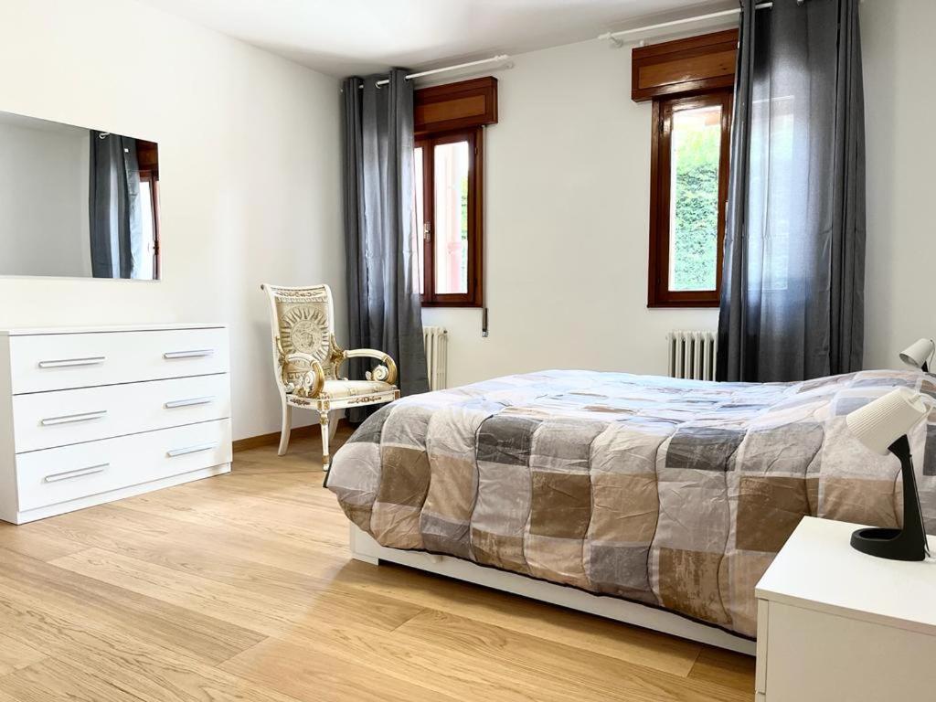 um quarto com uma cama, uma cómoda e uma cadeira em CENTRAL HOUSE em Piove di Sacco