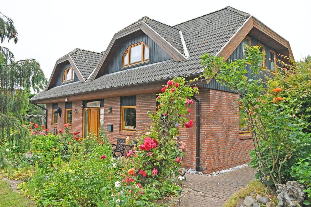 una pequeña casa con un patio de ladrillo con flores en Jasmunder Ferienwohnung, en Sagard